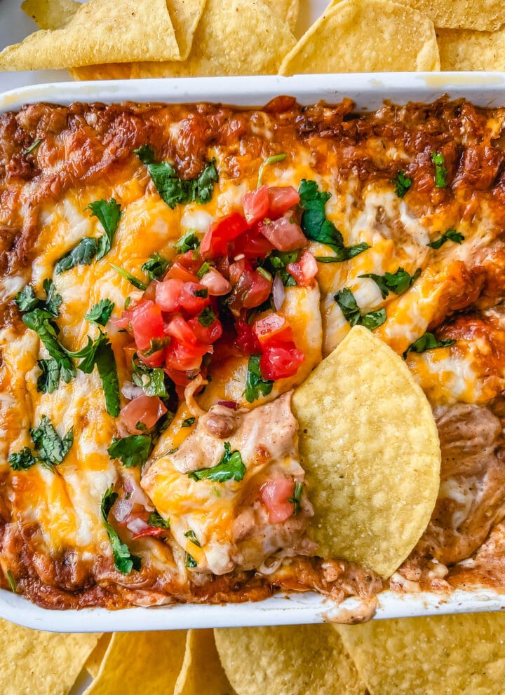 This is the best bean dip recipe ever! This is such an easy bean and cheese dip made with creamy beans, sour cream, cream cheese, taco seasoning, hot sauce, and lots of Mexican cheese! This easy bean dip is the best appetizer recipe. 