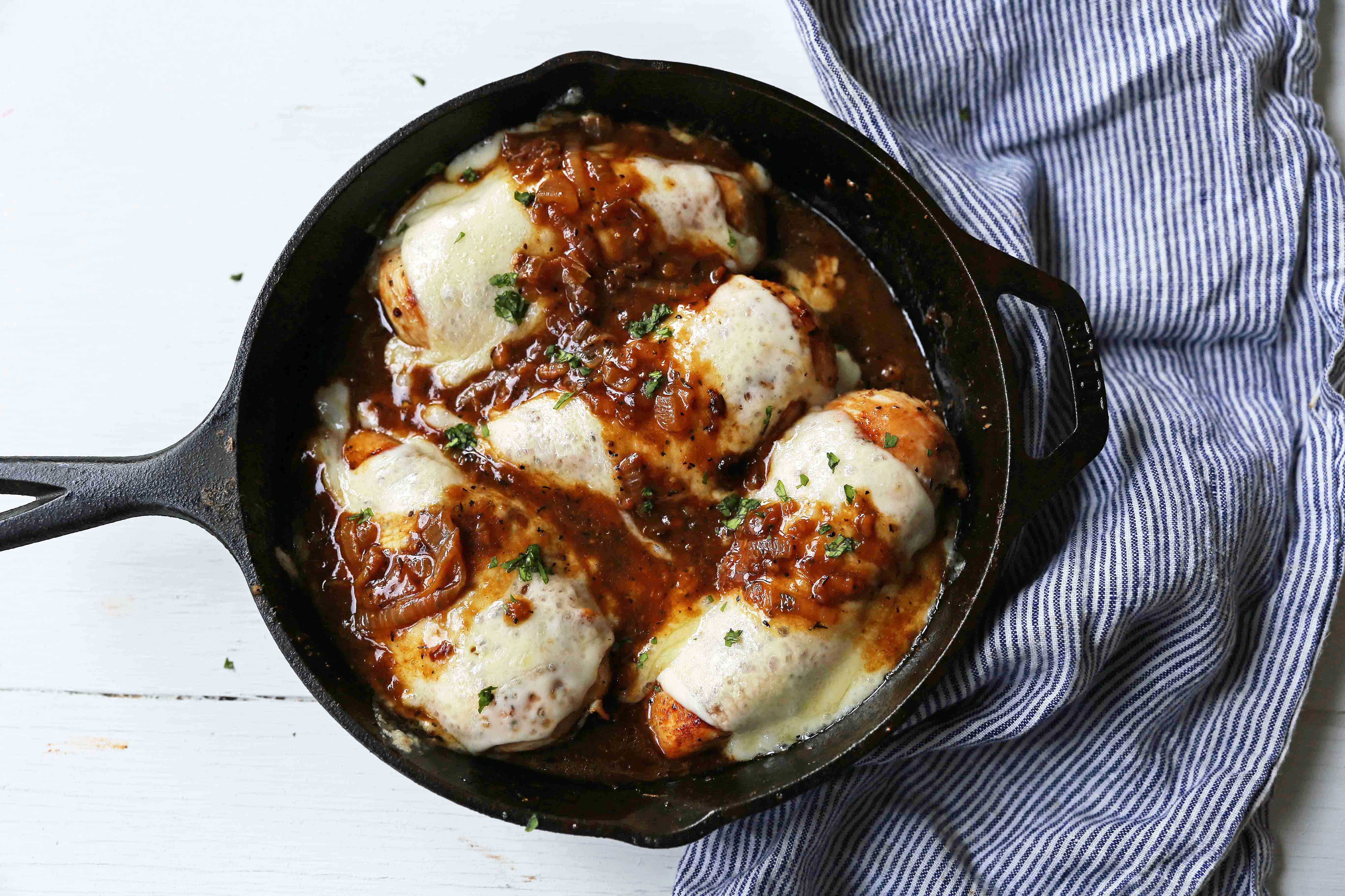 French Onion Chicken Skillet Chicken with Buttery Caramelized Onion Gravy and Melted Cheeses. A simple, flavorful, 30-minute meal! www.modernhoney.com #30minutemeal #dinnerrecipe #frenchonionchicken #cheesychicken #chickendinner