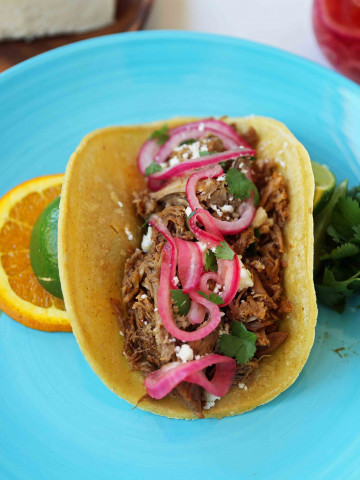 Mexican Pork Carnitas Tacos. Slow Cooker Pork Carnitas with Pickled Onions. How to make tender and flavorful pork carnitas slow cooked in Coca-Cola and citrus juices. www.modernhoney.com #tacos #carnitas #porkcarnitas #slowcooker #slowcookercarnitas