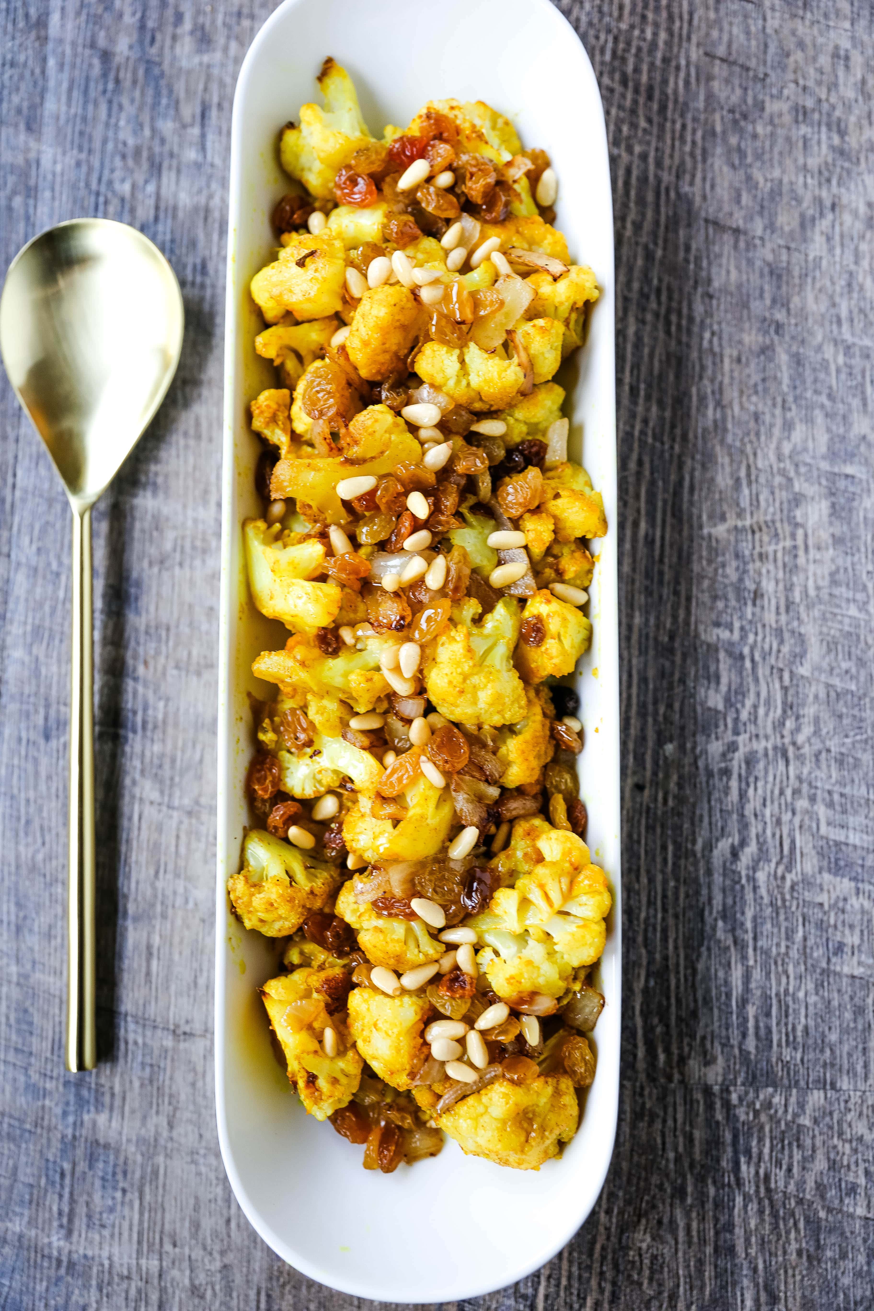 Turmeric Roasted Cauliflower Indian spiced roasted cauliflower with warm spices, caramelized onions, sweet golden raisins, and crunchy pine nuts. A flavorful, healthy side dish perfect for any occasion! www.modernhoney.com #cauliflower #sidedish #roastedvegetables #indianfood 